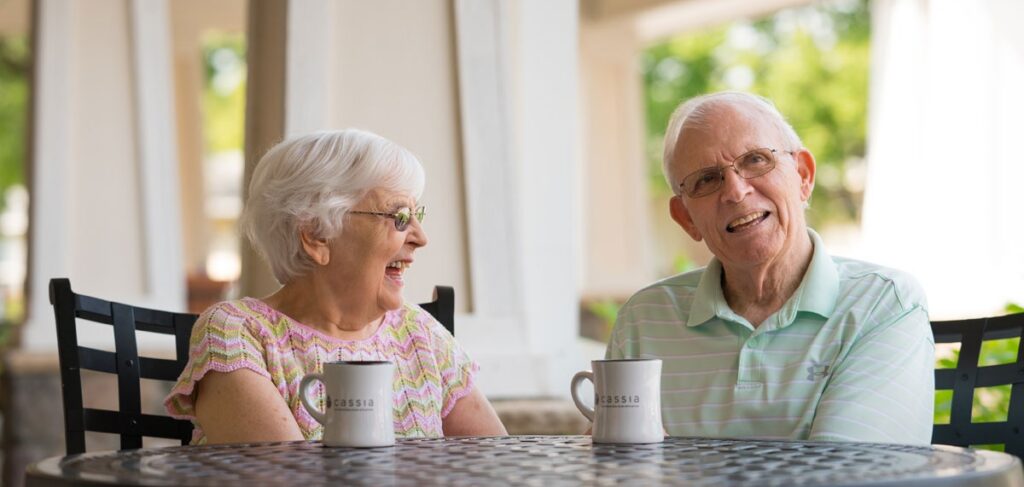 Two seniors sharing coffee during a conversation about transitioning to senior living at Valley View Village.