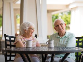 Two seniors sharing coffee during a conversation about transitioning to senior living at Valley View Village.